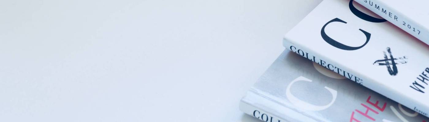 Stack of magazines arranged on a clean, minimal background.